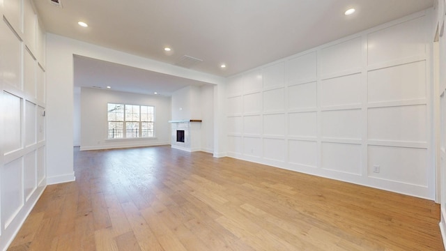 108 Shadow Springs Dr Unit 108, Brentwood, TN 37027 - unfurnished living room featuring recessed lighting, a fireplace, a decorative wall, and light wood-style flooring