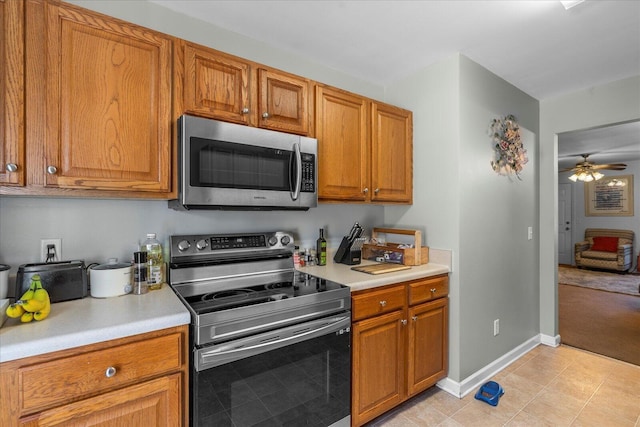9051 Haileys Pond Dr, Ooltewah, TN 37363 - kitchen with brown cabinetry, ceiling fan, appliances with stainless steel finishes, and light countertops
