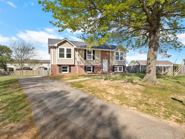 302 Windrush Dr, Clarksville, TN 37042 - bi-level home featuring brick siding, a front yard, aphalt driveway, and fence