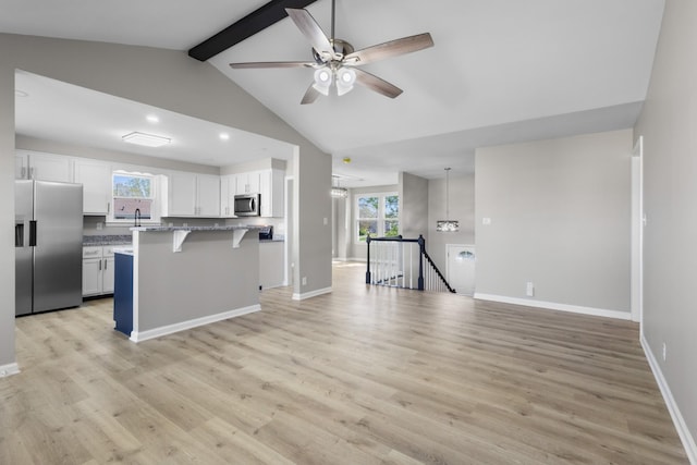 302 Windrush Dr, Clarksville, TN 37042 - kitchen with white cabinets, a kitchen breakfast bar, stainless steel appliances, vaulted ceiling with beams, and ceiling fan