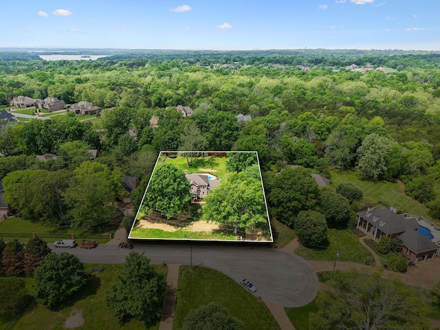 bird's eye view with a wooded view