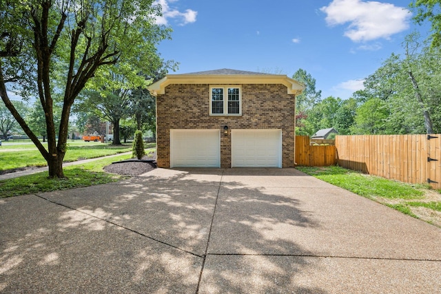 view of property exterior with brick siding, a garage, fence, and driveway