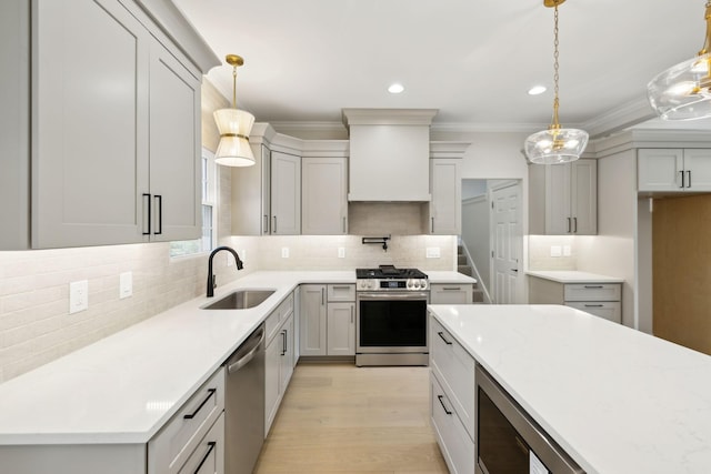kitchen with tasteful backsplash, a sink, light wood-style floors, stainless steel appliances, and recessed lighting