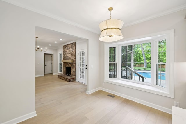 unfurnished dining area with crown molding, a chandelier, baseboards, wood finished floors, and visible vents