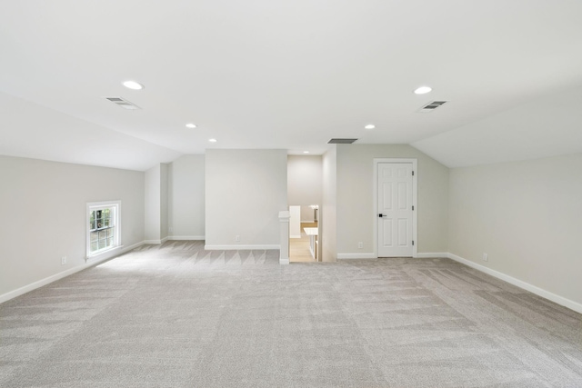 bonus room featuring vaulted ceiling, light colored carpet, and visible vents