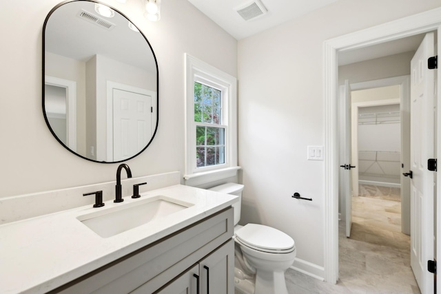 bathroom featuring vanity, baseboards, toilet, and visible vents