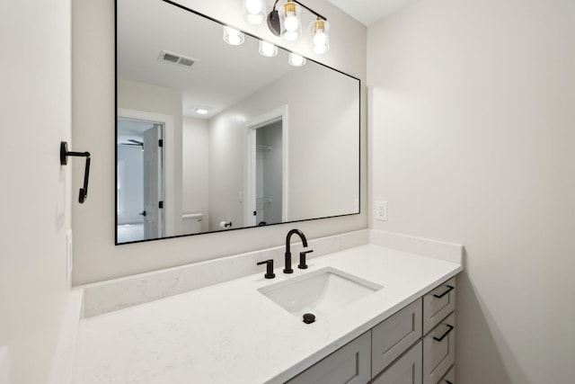 bathroom featuring vanity, toilet, and visible vents