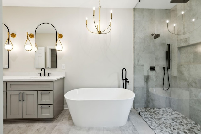 bathroom featuring vanity, marble finish floor, walk in shower, a soaking tub, and a notable chandelier