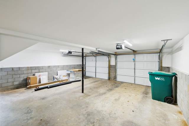 garage with concrete block wall and a garage door opener