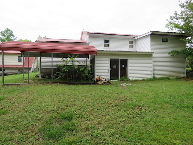 rear view of house with a lawn and metal roof