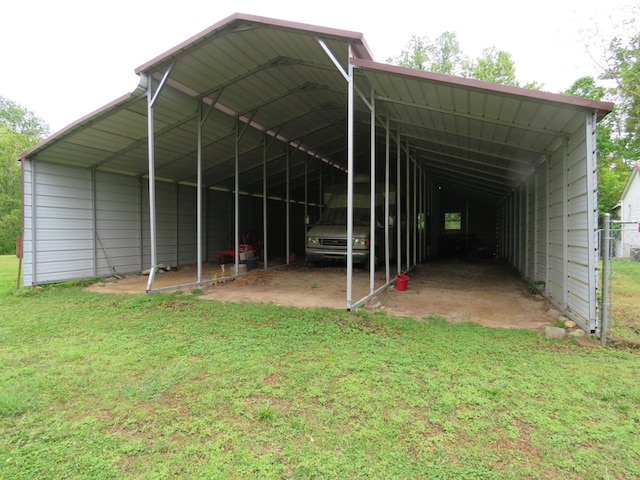 view of parking with fence and a detached carport