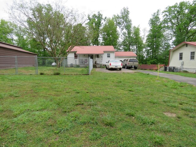 view of yard with fence and aphalt driveway