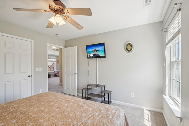 carpeted bedroom with baseboards, a ceiling fan, and visible vents