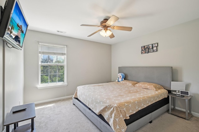 carpeted bedroom with visible vents, baseboards, and ceiling fan