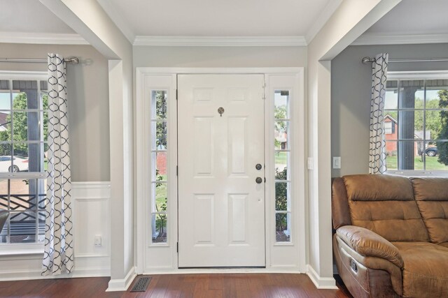 foyer entrance with dark wood finished floors and crown molding
