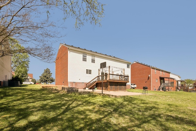 rear view of property featuring a wooden deck, a patio, a yard, and stairs