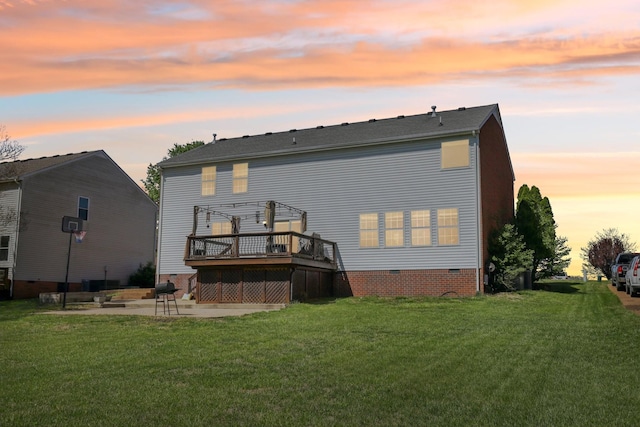 back of house at dusk with crawl space, a pergola, a deck, a yard, and a patio