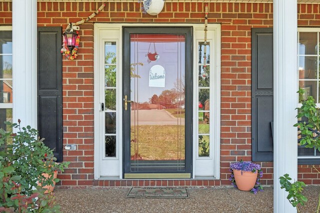 entrance to property featuring brick siding