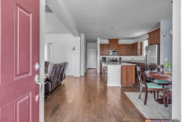3728 Hoggett Ford Rd, Hermitage, TN 37076 - kitchen featuring dark wood-style floors, visible vents, a kitchen island, a kitchen bar, and appliances with stainless steel finishes