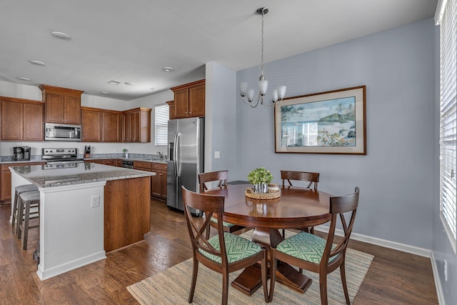 3728 Hoggett Ford Rd, Hermitage, TN 37076 - kitchen with brown cabinetry, dark wood-style flooring, stainless steel appliances, and an inviting chandelier