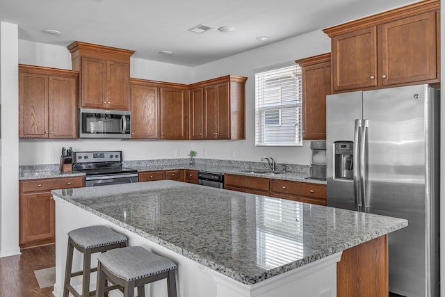 3728 Hoggett Ford Rd, Hermitage, TN 37076 - kitchen featuring stainless steel appliances, a sink, light stone countertops, a center island, and dark wood-style flooring