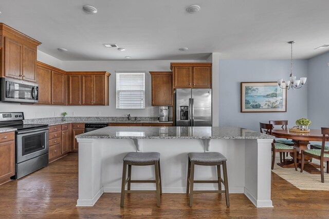 3728 Hoggett Ford Rd, Hermitage, TN 37076 - kitchen featuring stainless steel appliances, dark wood-type flooring, light stone countertops, a kitchen bar, and a notable chandelier
