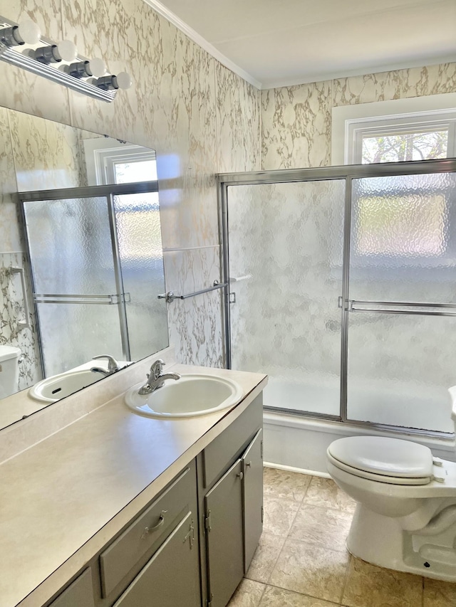 full bath featuring toilet, crown molding, vanity, and shower / bath combination with glass door
