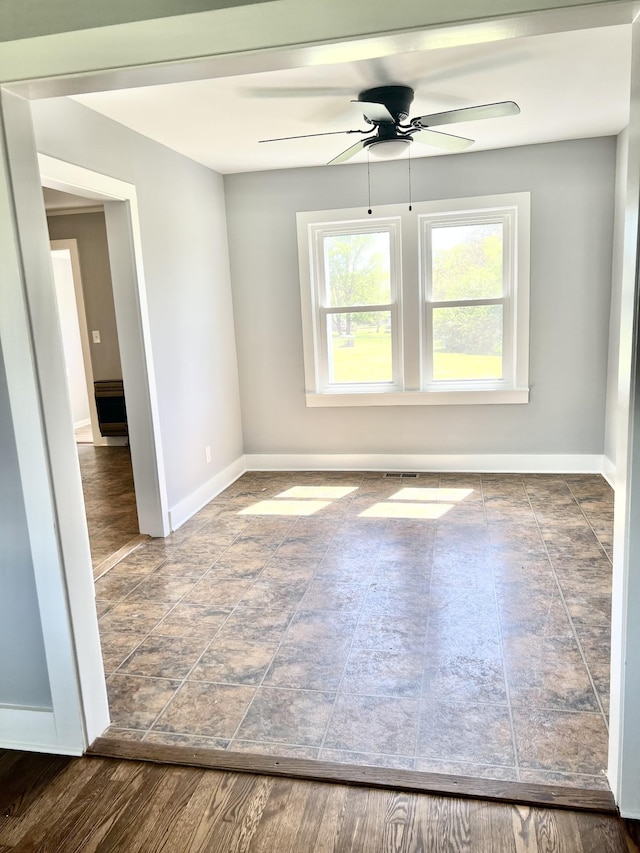 spare room with baseboards and ceiling fan