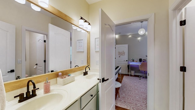 ensuite bathroom featuring ensuite bathroom, a sink, double vanity, and toilet