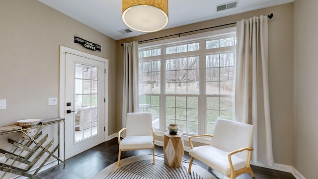 doorway featuring baseboards, visible vents, and dark tile patterned floors