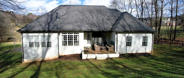 back of property with roof with shingles, a yard, and stucco siding