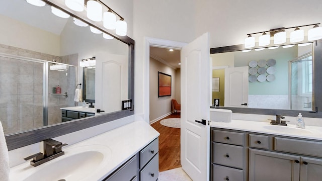 bathroom with two vanities, a stall shower, and a sink