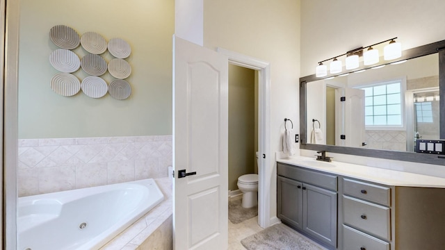 bathroom with toilet, vanity, and a jetted tub