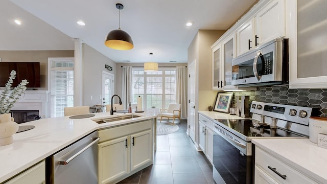 kitchen featuring light countertops, decorative light fixtures, appliances with stainless steel finishes, and a sink