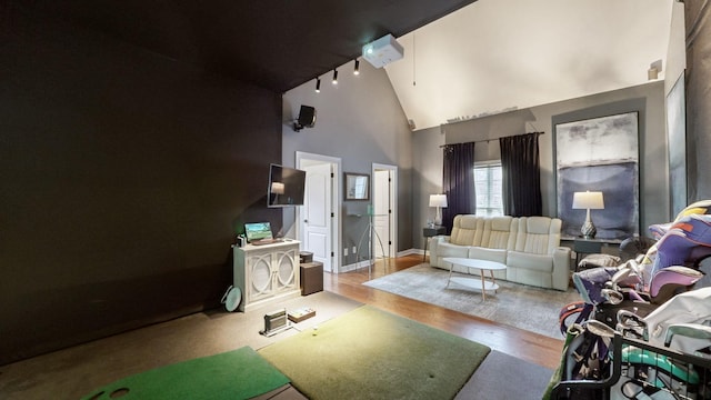 living area featuring high vaulted ceiling, baseboards, and wood finished floors