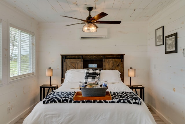 bedroom featuring baseboards, wood finished floors, a wall unit AC, and multiple windows