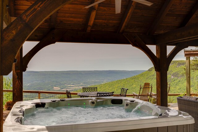deck with a hot tub and a mountain view