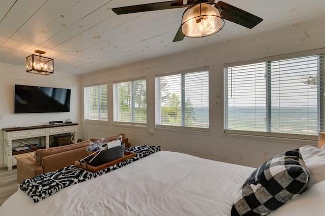 bedroom with wood finished floors, ceiling fan, and multiple windows