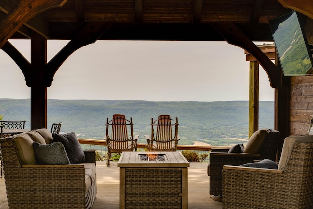view of patio featuring an outdoor fire pit and a mountain view