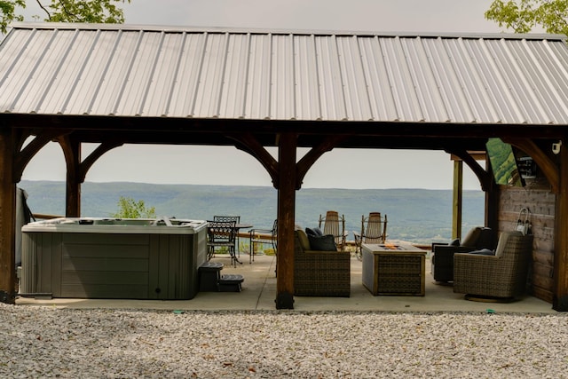 view of patio featuring a gazebo, a water view, and an outdoor fire pit