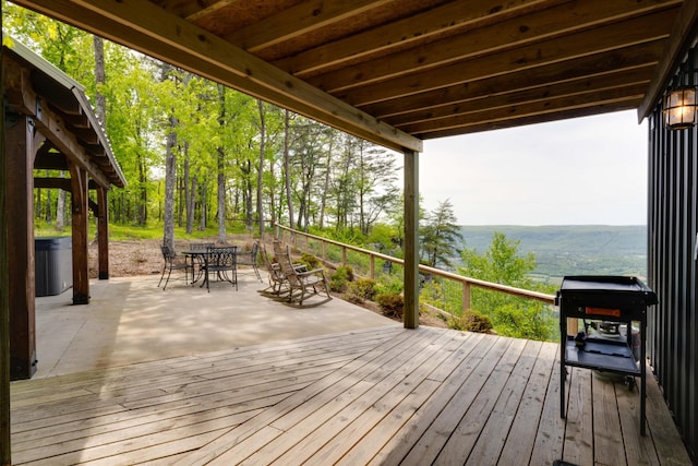 wooden deck with a patio area, outdoor dining area, and central AC unit