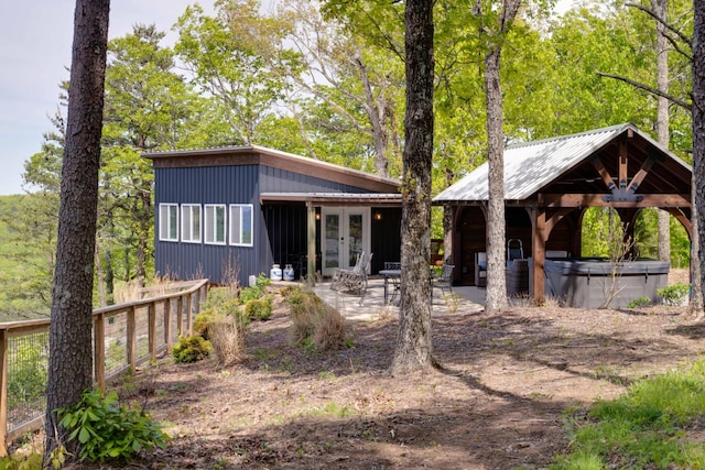 view of front facade with a patio area, french doors, a hot tub, and a gazebo