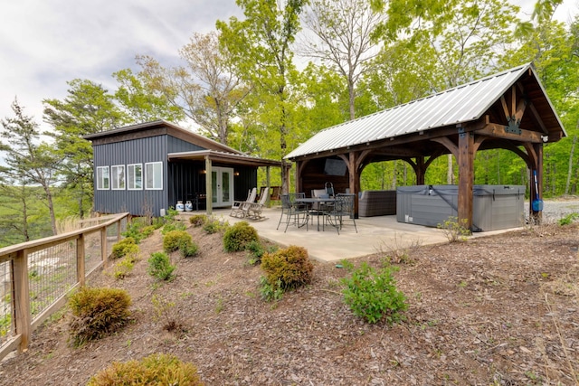 exterior space with a gazebo, a hot tub, and a patio area
