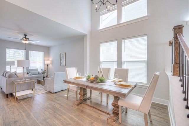 1084 Linn Cove Ct, Gallatin, TN 37066 - dining room with ceiling fan with notable chandelier, baseboards, wood finished floors, and a high ceiling