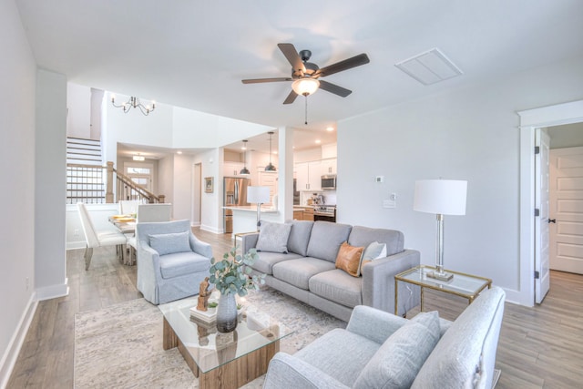 1084 Linn Cove Ct, Gallatin, TN 37066 - living room with baseboards, light wood finished floors, stairs, and ceiling fan with notable chandelier