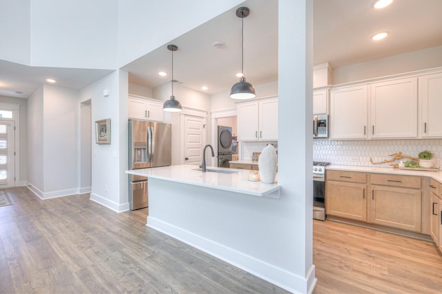 1084 Linn Cove Ct, Gallatin, TN 37066 - kitchen featuring a sink, tasteful backsplash, light wood-type flooring, light countertops, and appliances with stainless steel finishes