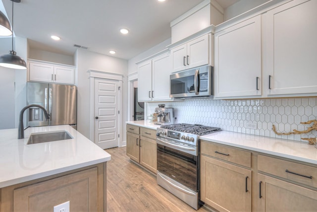 1084 Linn Cove Ct, Gallatin, TN 37066 - kitchen featuring light wood-style flooring, a sink, visible vents, decorative backsplash, and appliances with stainless steel finishes