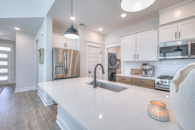 1084 Linn Cove Ct, Gallatin, TN 37066 - kitchen with stainless steel appliances, a sink, visible vents, decorative backsplash, and stacked washer / drying machine