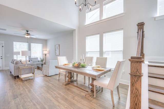 1084 Linn Cove Ct, Gallatin, TN 37066 - dining room featuring light wood-type flooring, a towering ceiling, baseboards, and ceiling fan with notable chandelier