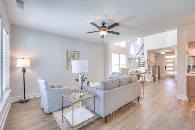 1084 Linn Cove Ct, Gallatin, TN 37066 - living area featuring visible vents, baseboards, wood finished floors, stairs, and ceiling fan